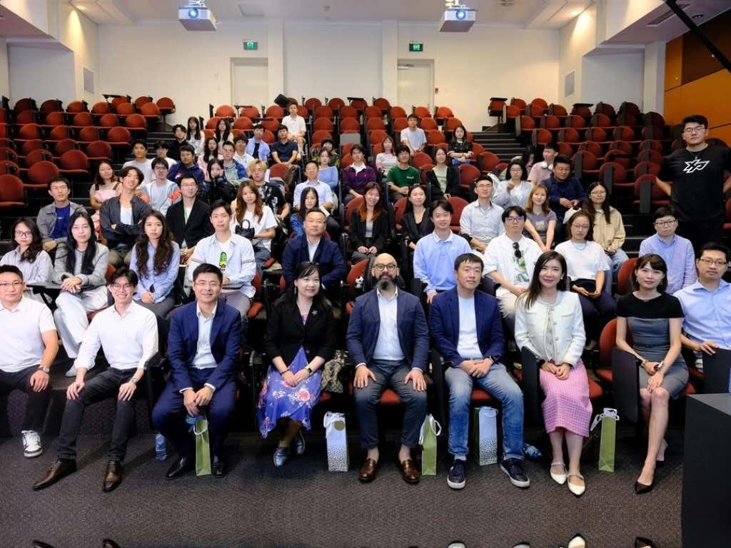 学生与嘉宾坐在大学阶梯教室里合影