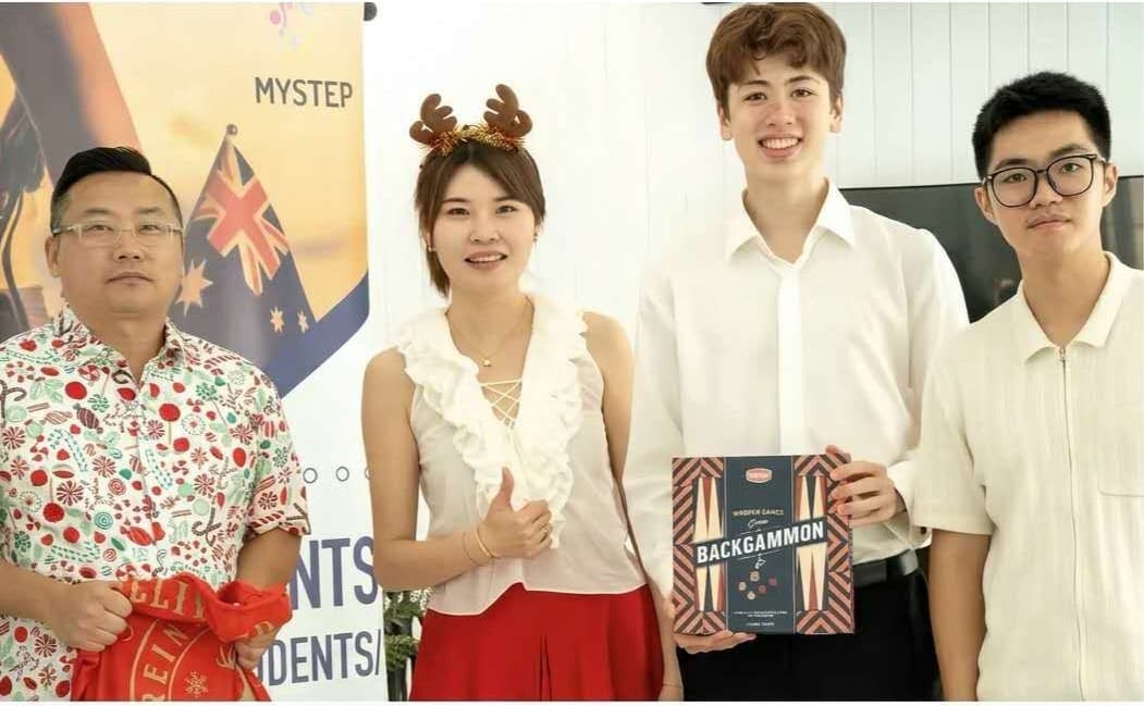 节日聚会上,委员会成员与嘉宾手持桌游合影